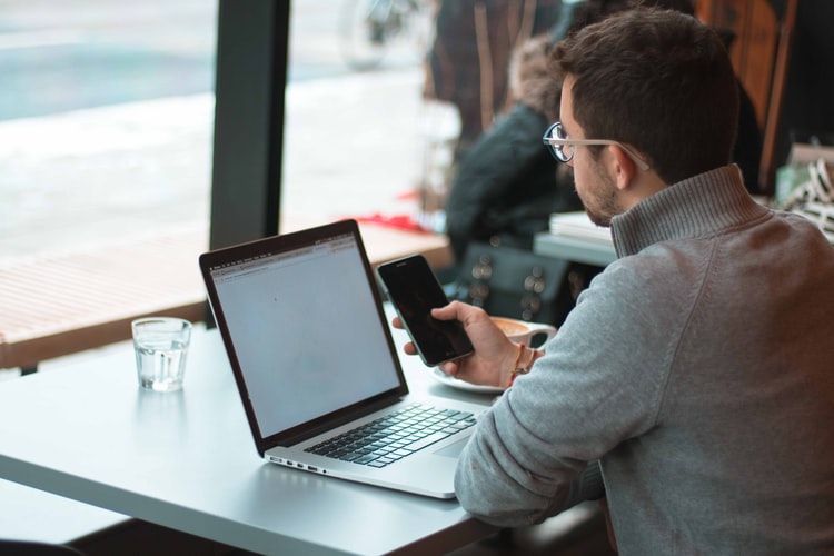 man checking security camera on laptop