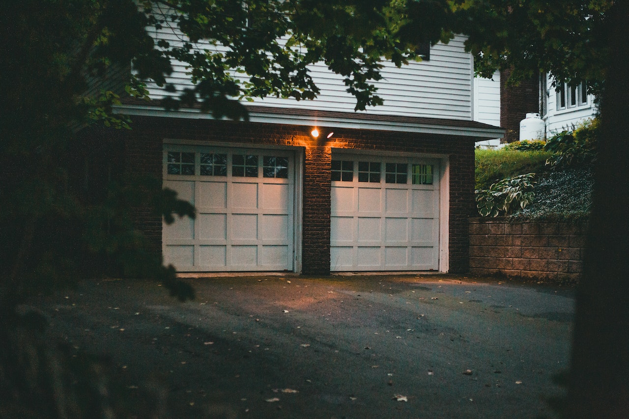 Two white garage doors of a secluded home.