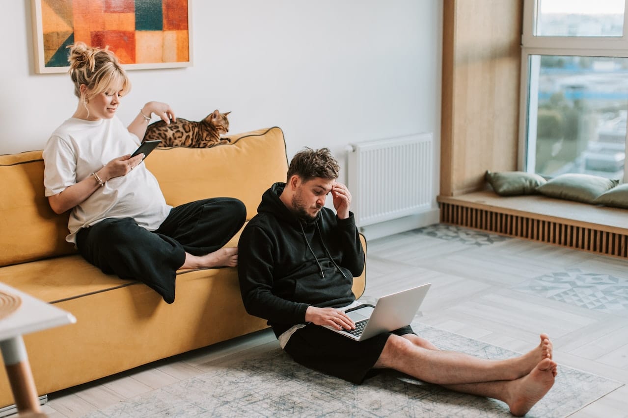 a man and woman using smart devices inside their home