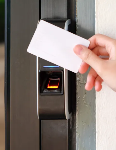 Person using a key card to open door