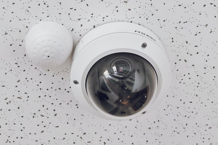 a round white security camera mounted on a ceiling